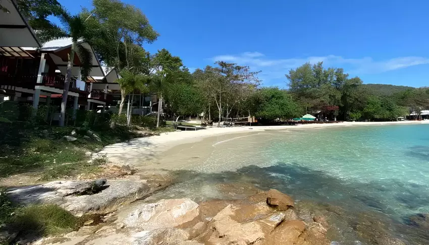 Спокойный пляж Ао Табтим с ясной водой, окруженный тропической зеленью